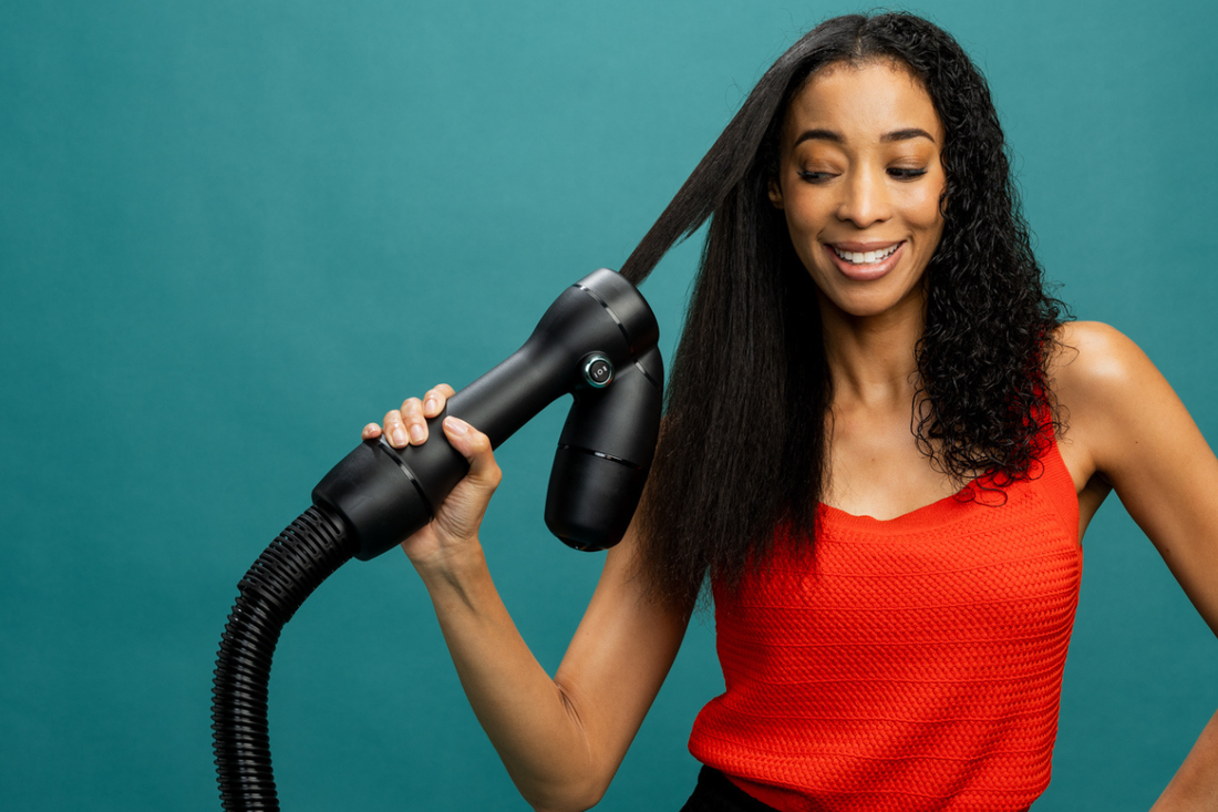 Young Black Woman Using RevAir to Stretch her Type 3 curly hair