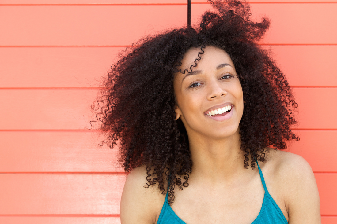 young-woman-smiling-outdoors-textured-curly-hair