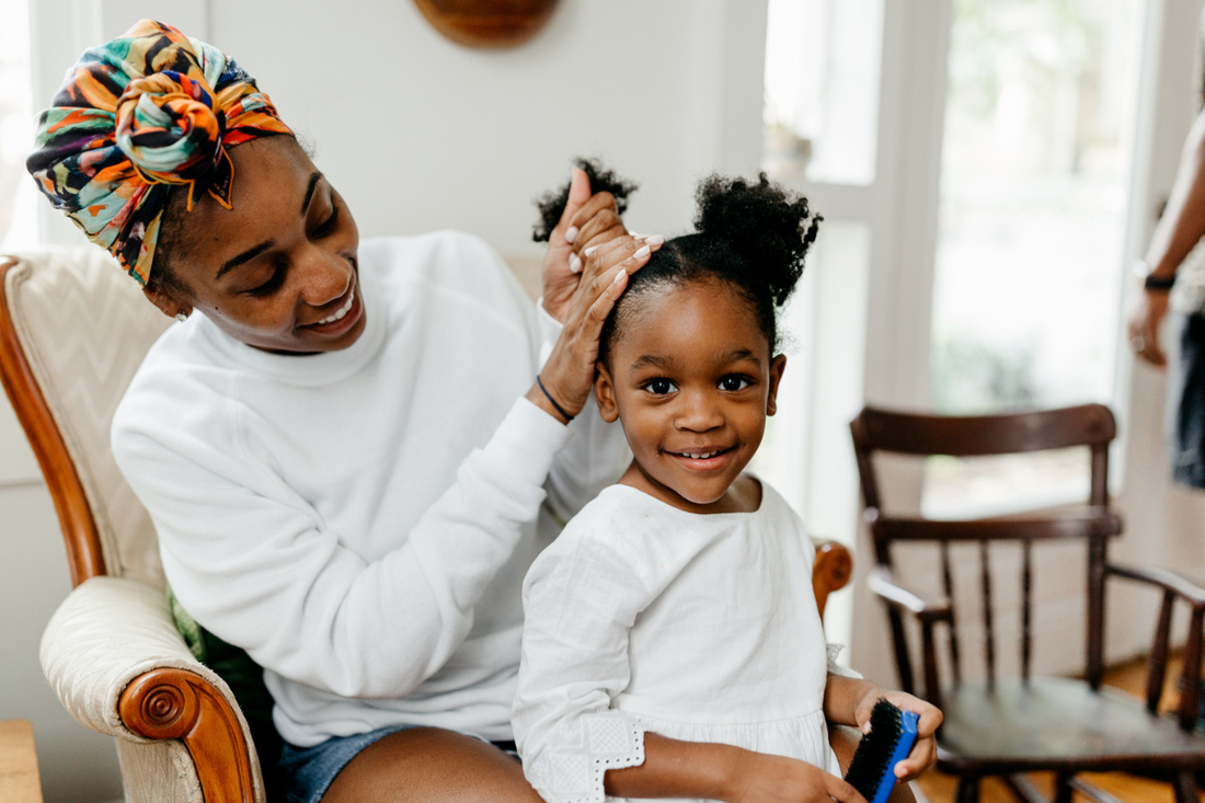 Mother fixing daughters hair