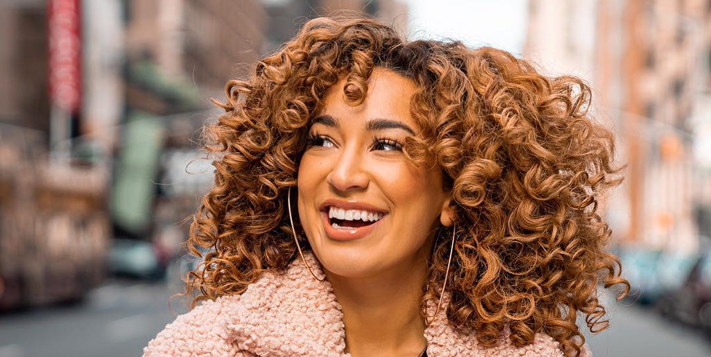 hispanic-woman-with-natural-hair-posing-posing-outdoor-while-looking-at-camera
