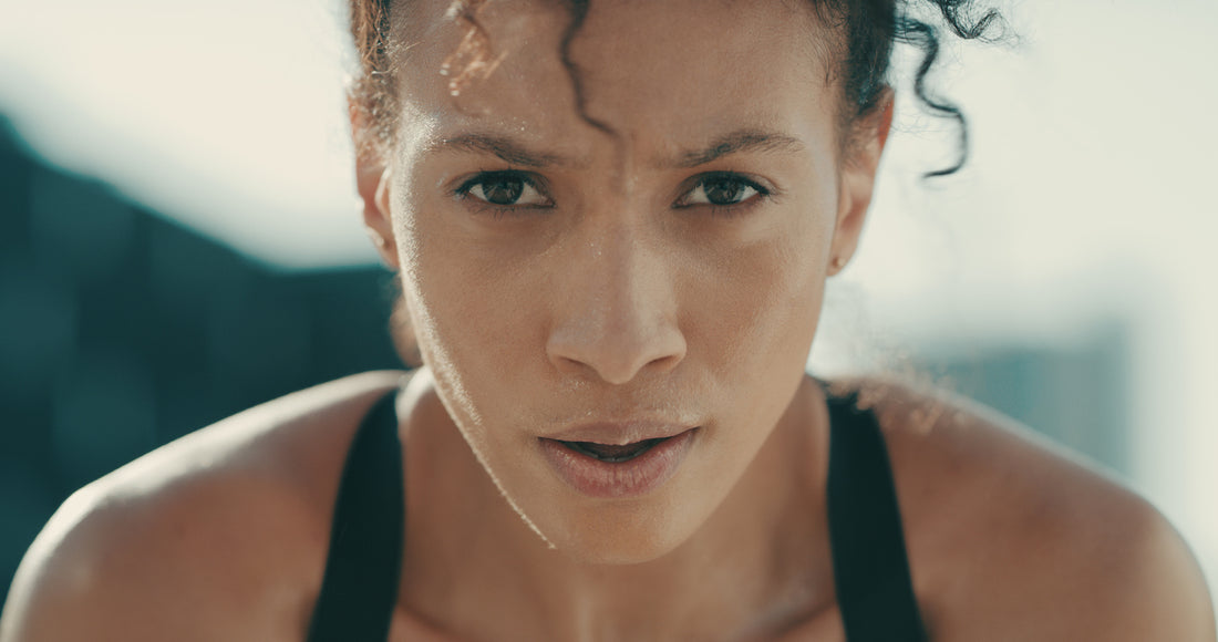 Beautiful woman with dark curly hair seating during a workout