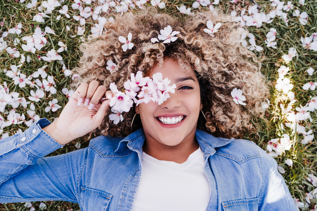 woman-with-curly-hairstyle-holding-yellow-tulips
