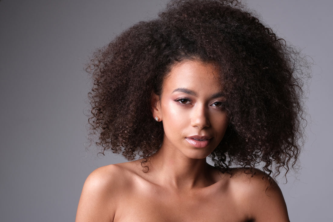 woman-with-natural-curly-hair-on-gray-background-transitioning-hairstyles-concept