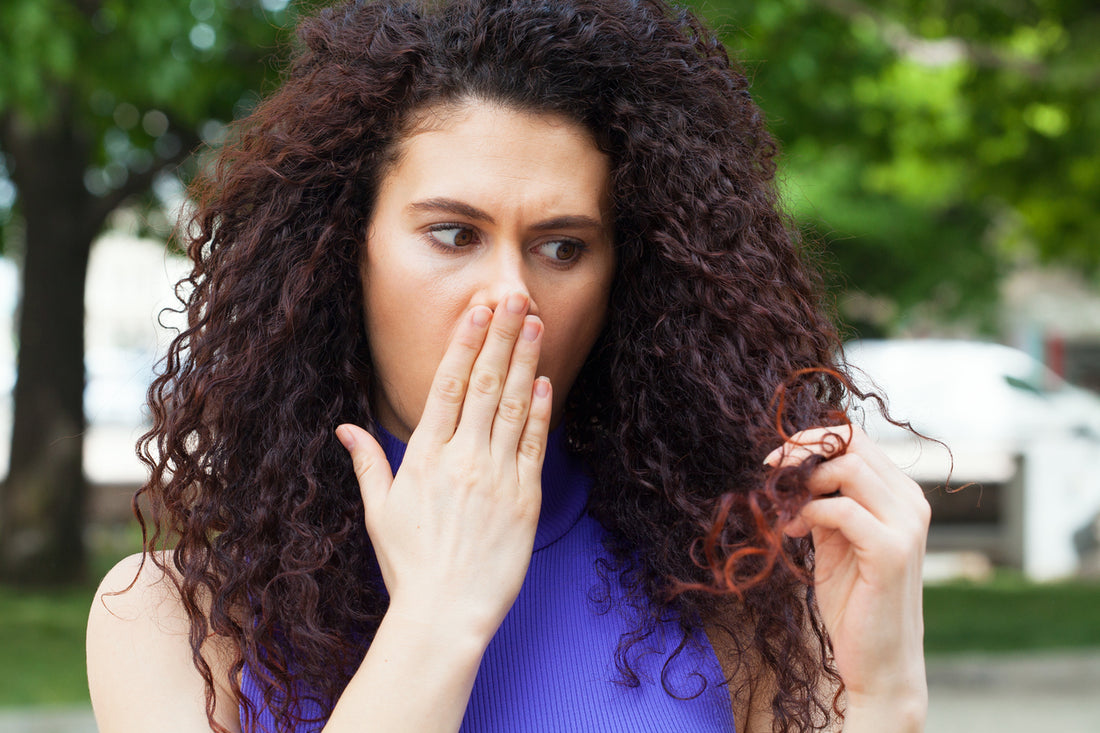 woman-with-curly-hair-looking-at-split-ends