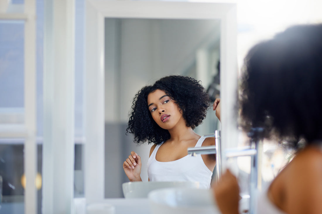woman styling curly / coily hair in between washdays