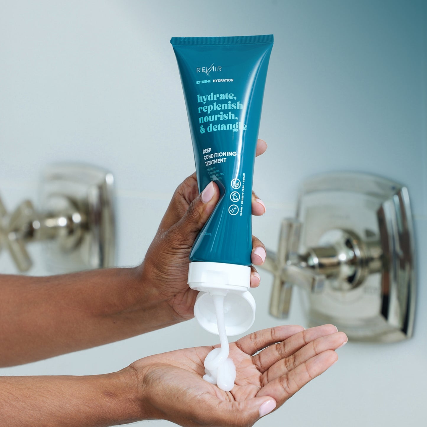 Woman squeezing RevAir deep conditioning treatment onto her palm, showing creamy texture