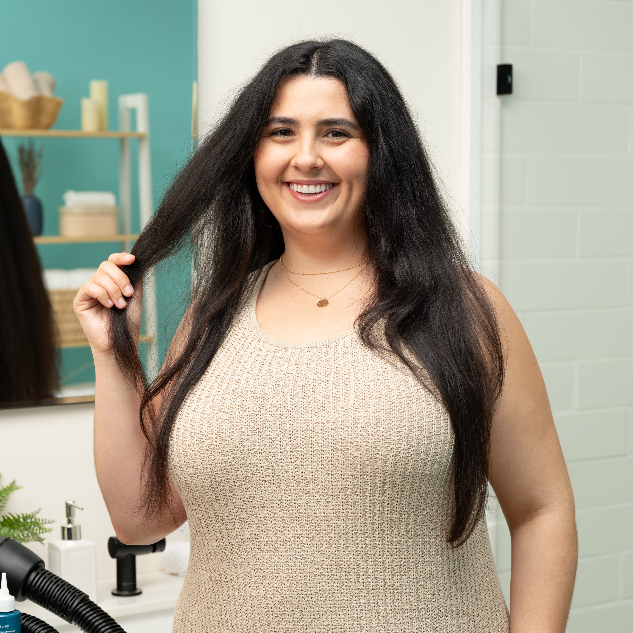 Woman standing in bathroom and showing off her finished, straightened hair after using RevAir dryer