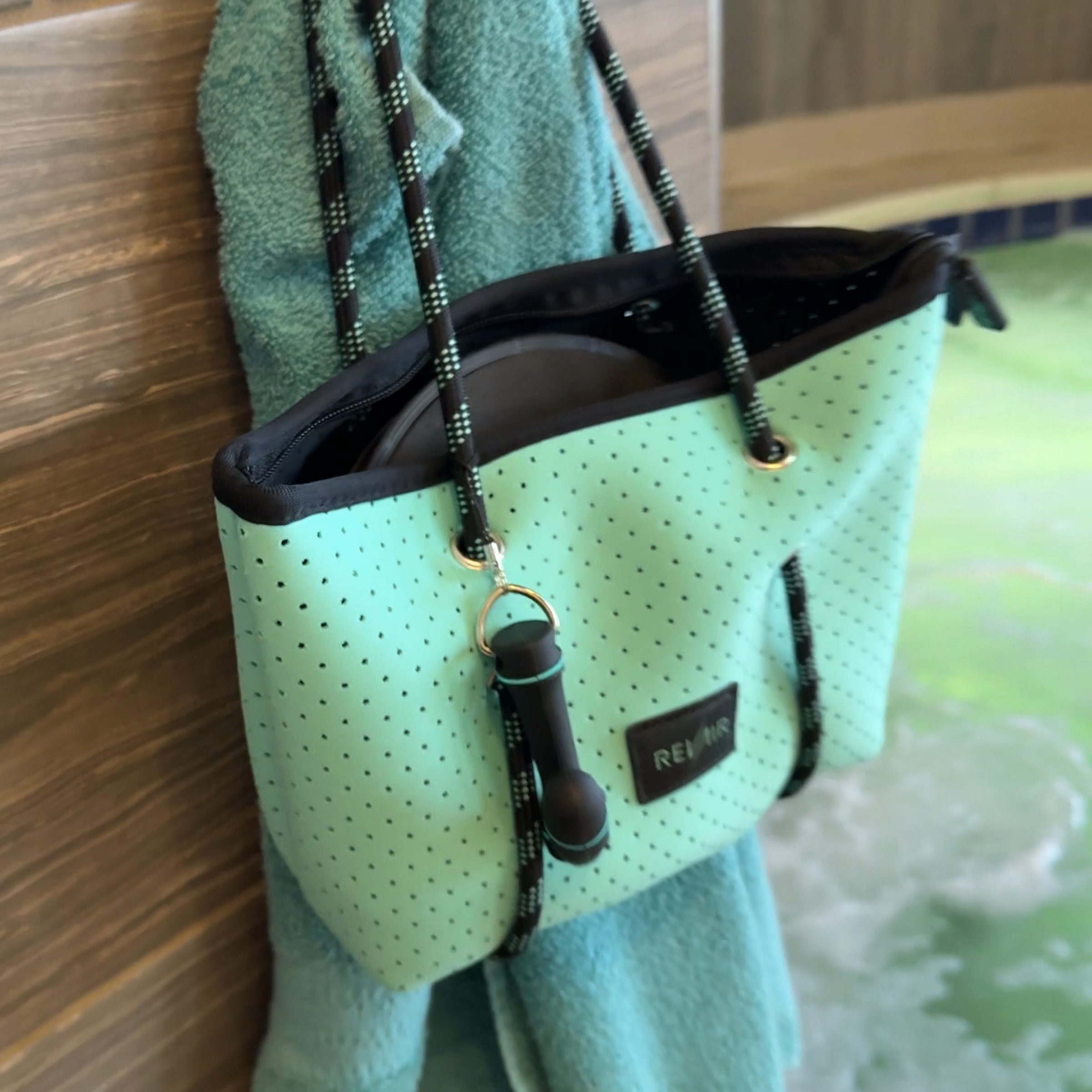 Sidekick tote bag hanging on towel hook in a hot tub/spa room