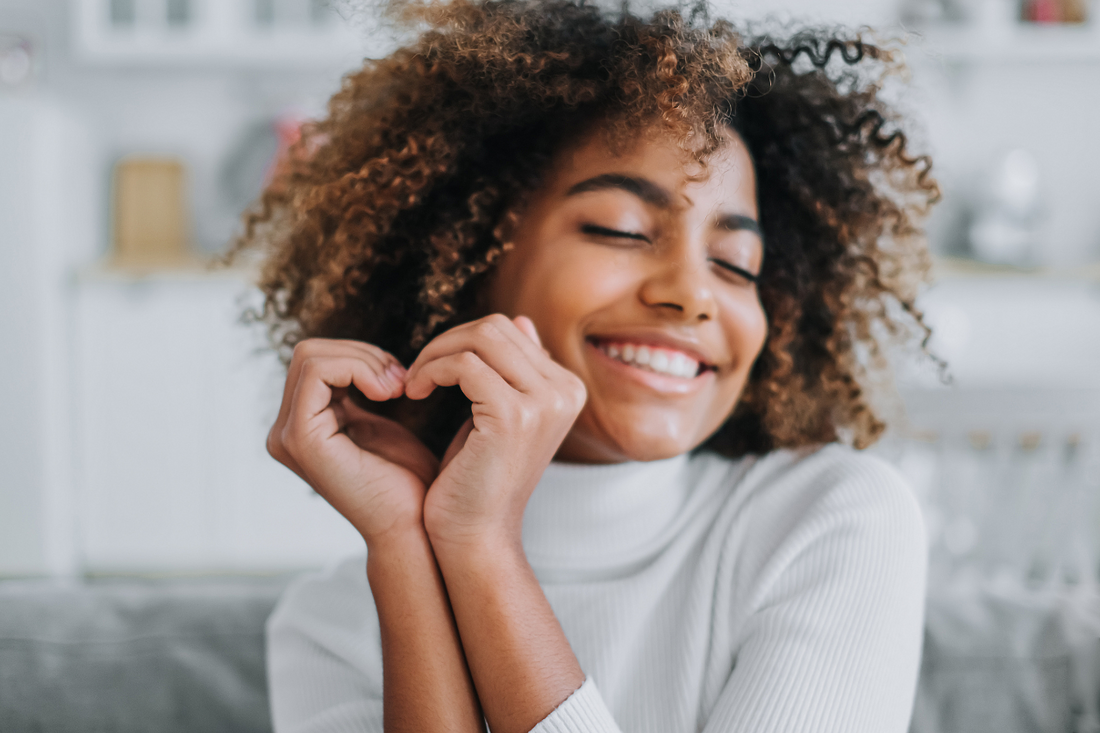 Young happy girl making heart with her hands