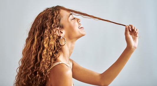 A picture of a beautiful woman stretching her curly hair.