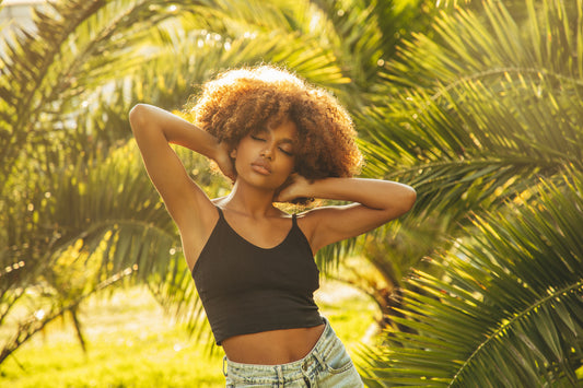 young-woman-with-natural-curls-among-palm-trees