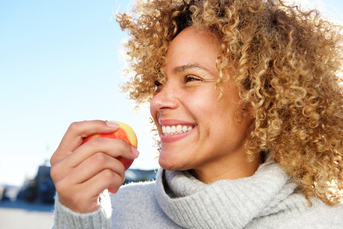 close-up-side-portrait-of-a-woman-with-healthy-hair-holding-an-apple