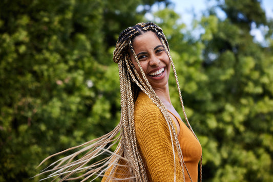 woman-twirling-her-long-braided-hair-outdoors-protective-styles-concept