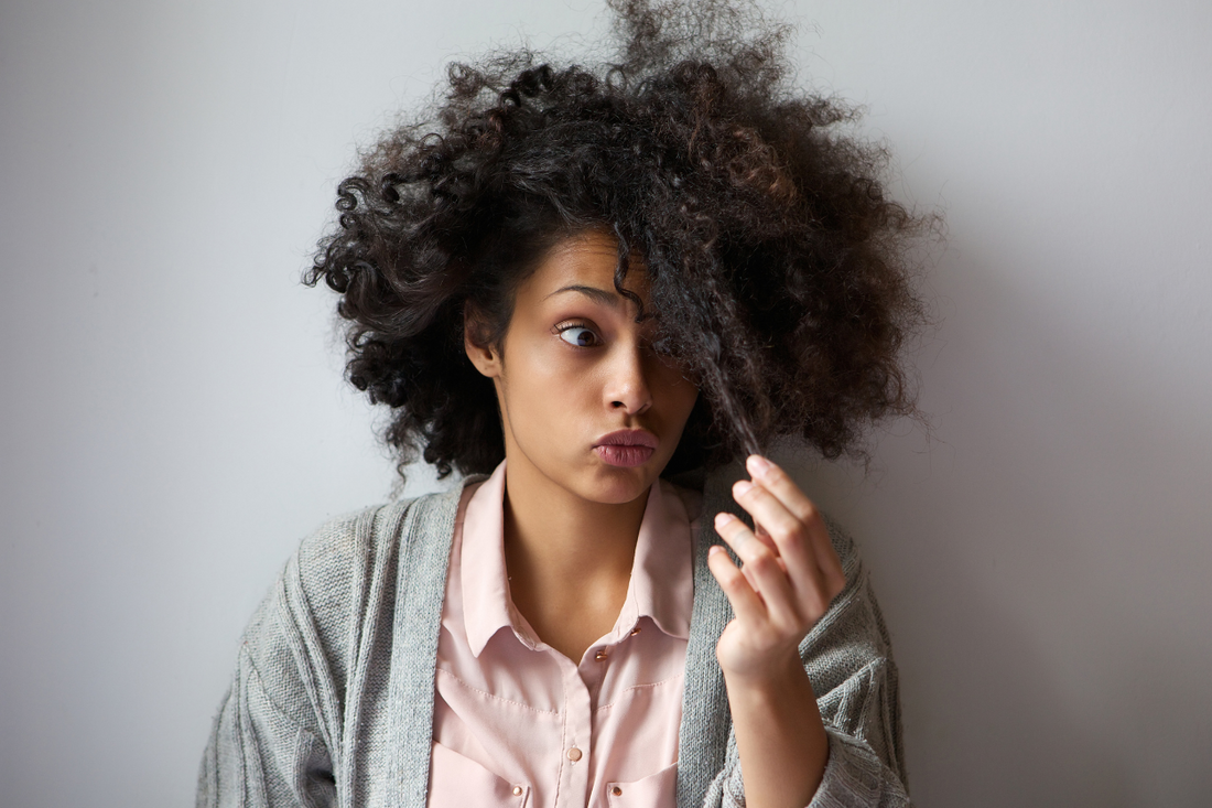 Woman inspecting curly hair