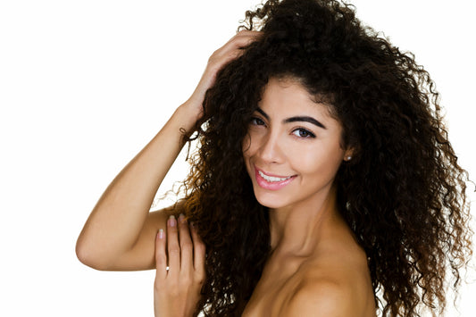 Young woman with her hand on her long, curly hair