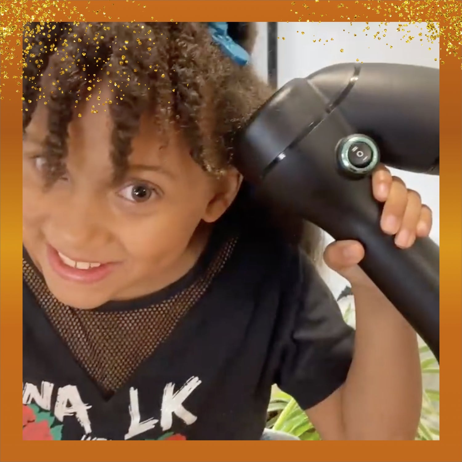 A girl with coily hair smiling while revving her hair