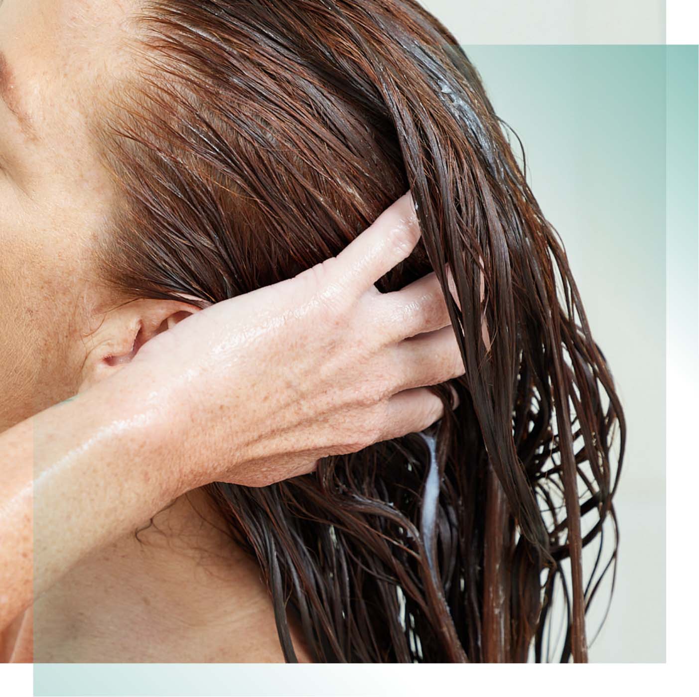 Woman working product through her wet hair