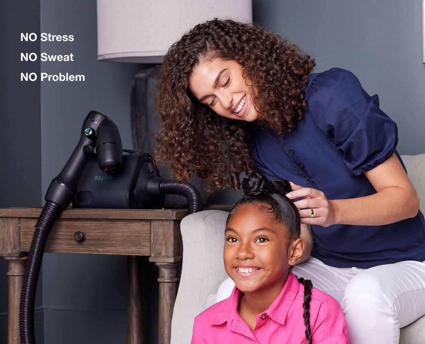 Mother styling daughter's hair with the RevAir device nearby and the words: No stress, no sweat, no problem