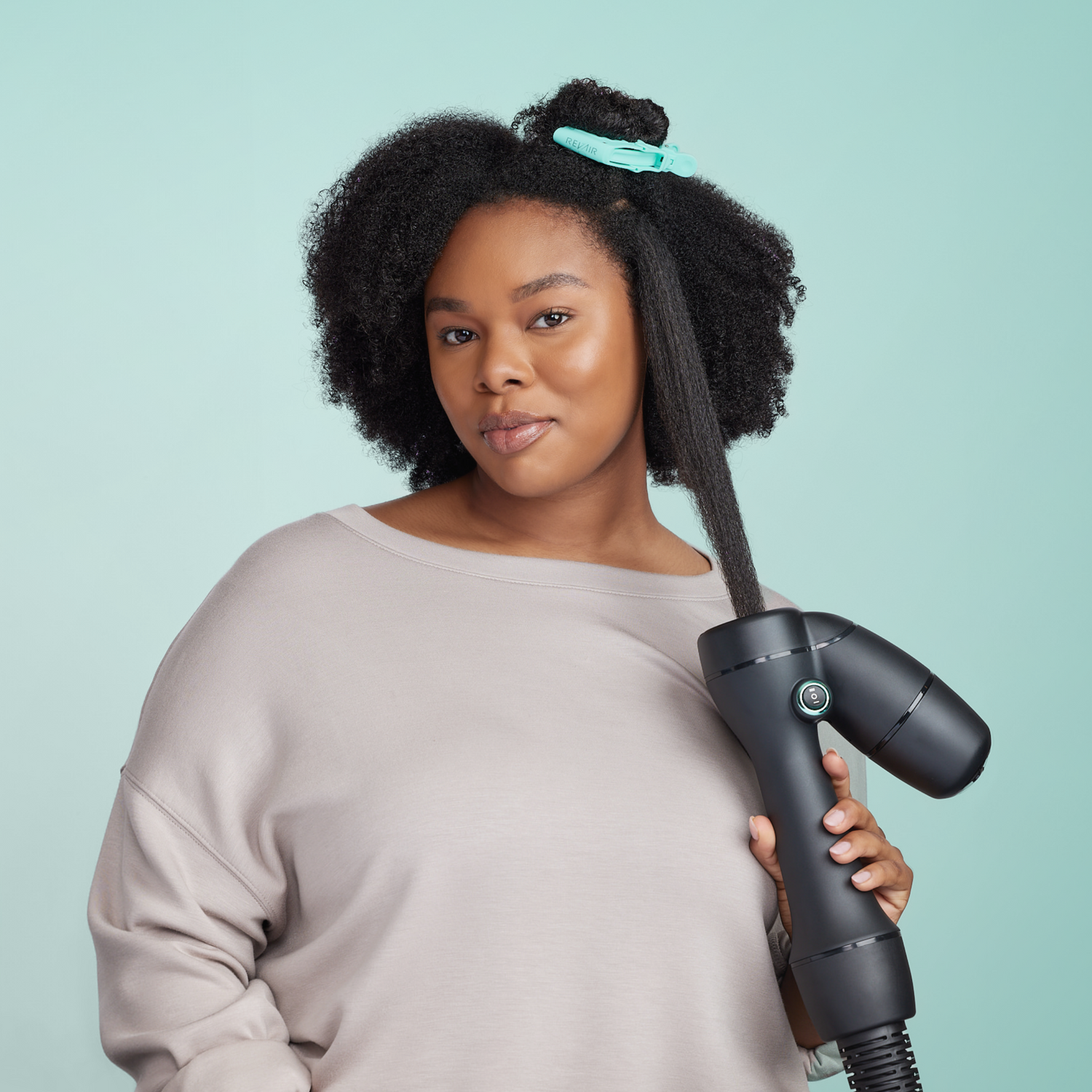 Woman with type 4 coily hair using the RevAir dryer wand to stretch her hair