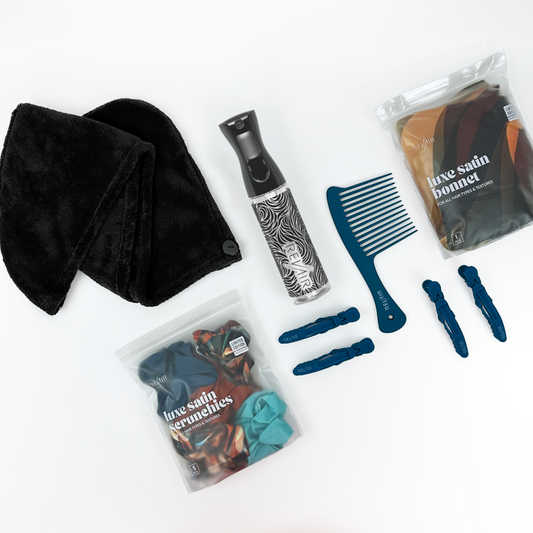 Collection of RevAir hair care products including a towel, spray bottle, comb, and hair accessories on a white background.