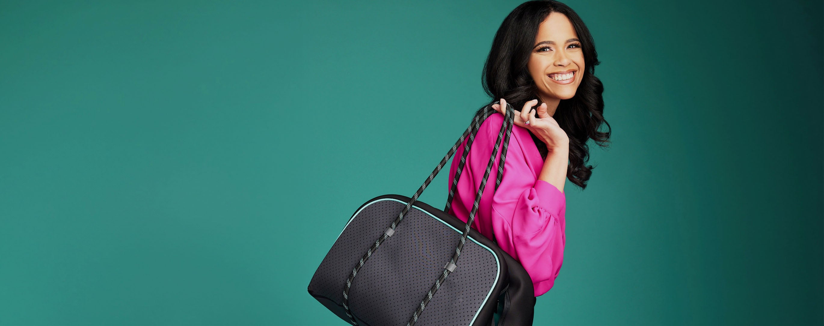 Smiling woman carrying the RevAir Weekender Bag slung over shoulder