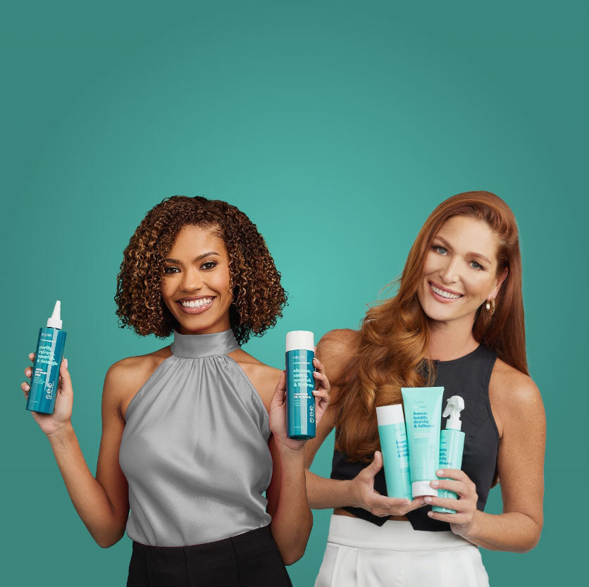 Two women holding up RevAir hair products and smiling